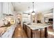 Open kitchen layout with white cabinets, a central island, and stainless steel appliances at 455 Forest St, Denver, CO 80220