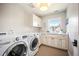 Bright laundry room featuring white cabinets and modern washer and dryer units at 455 Forest St, Denver, CO 80220