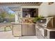 An outdoor kitchen features stone countertops, stainless steel appliances, and a built-in grill at 455 Forest St, Denver, CO 80220