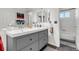 Bathroom featuring a modern double vanity sink with gray cabinetry and a view of the tub at 6266 Holman St, Arvada, CO 80004