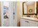 Bathroom with vanity, mirror and decor with a view into a bedroom, offering convenience and functionality for everyday use at 8403 S Miller Ct, Littleton, CO 80127