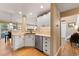 Well-lit kitchen with stainless steel appliances, white cabinets, and a view into the living room, perfect for entertaining at 8403 S Miller Ct, Littleton, CO 80127