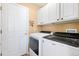 Convenient laundry area with modern washer and dryer, and ample storage cabinets at 8403 S Miller Ct, Littleton, CO 80127