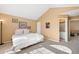 Bright main bedroom featuring neutral paint, vaulted ceilings, carpeted floors, and attached bathroom at 8403 S Miller Ct, Littleton, CO 80127