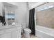 Tiled bathroom featuring a shower-over-tub and a vanity with a mirror; bright and functional at 14800 Hudson St, Thornton, CO 80602