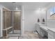 Bright bathroom features a glass-enclosed shower and vanity with double sinks, and granite countertops at 14800 Hudson St, Thornton, CO 80602