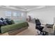 A spacious bedroom featuring neutral carpet, a work desk, and bright light through the windows at 14800 Hudson St, Thornton, CO 80602