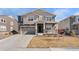 Two-story home featuring a covered front porch, a two-car garage, and neutral-tone siding at 14800 Hudson St, Thornton, CO 80602