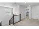 Upstairs hallway featuring neutral carpet, wood railing and a view into a bedroom with a window at 14800 Hudson St, Thornton, CO 80602