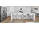 Modern kitchen with stainless steel refrigerator and a spacious island with bar stool seating at 14800 Hudson St, Thornton, CO 80602
