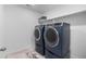 Laundry room featuring front-load washer and dryer with utility sink and neutral tile flooring at 14800 Hudson St, Thornton, CO 80602