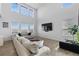 Open living room with soaring ceilings, large windows, and a comfortable sofa at 14800 Hudson St, Thornton, CO 80602