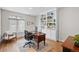 Well-lit home office featuring a large desk, built-in bookshelves, and a comfortable sitting area at 3315 Klondike Pl, Castle Rock, CO 80108