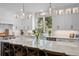 Bright kitchen with an oversized marble island, white cabinets, pendant lighting and stainless appliances at 3315 Klondike Pl, Castle Rock, CO 80108