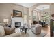Bright living room with a fireplace, comfortable seating, and seamless flow to the formal dining area at 3315 Klondike Pl, Castle Rock, CO 80108