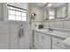 Bathroom with updated fixtures, white tile, and plenty of natural light from the window at 13957 E Louisiana Pl, Aurora, CO 80012