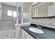 Bathroom featuring tile floor, glass enclosed shower, and large mirror at 13957 E Louisiana Pl, Aurora, CO 80012