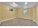 Bedroom featuring carpet, light yellow walls and two windows at 13957 E Louisiana Pl, Aurora, CO 80012