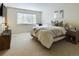 Comfortable bedroom with neutral carpet, a window, and a large bed with throw pillows at 5971 Windy St, Golden, CO 80403