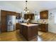 This kitchen features wood floors, stainless steel appliances, stylish lighting, and a large central island at 5971 Windy St, Golden, CO 80403