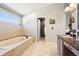 The bathroom features a large soaking tub with a luxurious quartz countertop and tile at 8288 W Chestnut Ave, Littleton, CO 80128