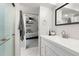 Bright bathroom with white cabinets, a modern faucet, and a shower with glass doors at 8288 W Chestnut Ave, Littleton, CO 80128