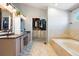 The primary bathroom features a double vanity with a walk-in closet and soaking tub at 8288 W Chestnut Ave, Littleton, CO 80128