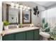 A well-lit bathroom boasts a double sink vanity with modern fixtures and green accents at 8288 W Chestnut Ave, Littleton, CO 80128