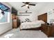 Bedroom featuring a wooden bed frame, a ceiling fan, and floating shelves at 8288 W Chestnut Ave, Littleton, CO 80128
