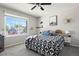 Cozy bedroom featuring a ceiling fan, a large window, and decoratively styled bed at 8288 W Chestnut Ave, Littleton, CO 80128