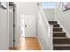 Bright entryway with hardwood floors, staircase, and a view of the front door at 8288 W Chestnut Ave, Littleton, CO 80128