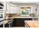 Bright kitchen featuring stainless steel appliances, white and black cabinets and updated countertops at 8288 W Chestnut Ave, Littleton, CO 80128