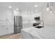Modern kitchen with white cabinets, stainless steel appliances, a large waterfall island, and elegant pendant lighting at 1308 Snowberry Ln # 301, Louisville, CO 80027