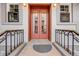 Close up of the red, glass-paneled front door with black iron railing at 215 E 11Th Ave # C3, Denver, CO 80203