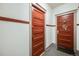 Hallway showing two red-painted unit doors with vintage hardware and trim at 215 E 11Th Ave # C3, Denver, CO 80203