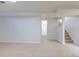 Bright basement space featuring neutral carpet and paint, next to the carpeted stairs at 10454 Grant Dr, Northglenn, CO 80233