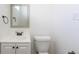 Clean and simple bathroom with a white vanity, toilet, mirror, and neutral decor at 10454 Grant Dr, Northglenn, CO 80233