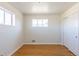 Bright bedroom featuring hardwood floors, neutral paint, and natural light from two windows at 10454 Grant Dr, Northglenn, CO 80233