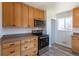 Well-lit kitchen with stainless steel appliances, wooden cabinets, and modern fixtures at 10454 Grant Dr, Northglenn, CO 80233