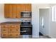 Functional kitchen layout with wooden cabinets, and stainless steel oven and microwave at 10454 Grant Dr, Northglenn, CO 80233