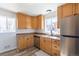 Cozy kitchen with wooden cabinets, stainless steel appliances, and a bright window at 10454 Grant Dr, Northglenn, CO 80233