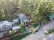 Aerial view of the property showcasing the home, outdoor areas, and surrounding landscape with mature trees at 27383 Highway 74, Evergreen, CO 80439