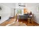Bright bedroom with hardwood floors, a rustic bed, and a large window providing ample natural light at 27383 Highway 74, Evergreen, CO 80439