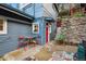 Exterior view of the home with a colorful door, small patio set, and a charming rustic appeal at 27383 Highway 74, Evergreen, CO 80439