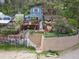 Charming blue two-story home with a deck and landscaped yard on a hillside at 27383 Highway 74, Evergreen, CO 80439