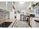Efficient kitchen with stainless steel appliances, open shelving and space for a washer and dryer at 27383 Highway 74, Evergreen, CO 80439