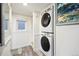 Convenient laundry area with stacked washer and dryer, complemented by bright, white walls at 27383 Highway 74, Evergreen, CO 80439