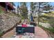 Relaxing outdoor patio with stylish furniture, rock wall, and a tranquil atmosphere surrounded by lush greenery at 27383 Highway 74, Evergreen, CO 80439