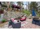 Inviting outdoor patio area with stone accents, comfortable seating, and a charming pergola in a serene setting at 27383 Highway 74, Evergreen, CO 80439