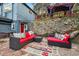 Charming outdoor patio featuring cozy seating, colorful accents, and a stone wall, perfect for entertaining at 27383 Highway 74, Evergreen, CO 80439